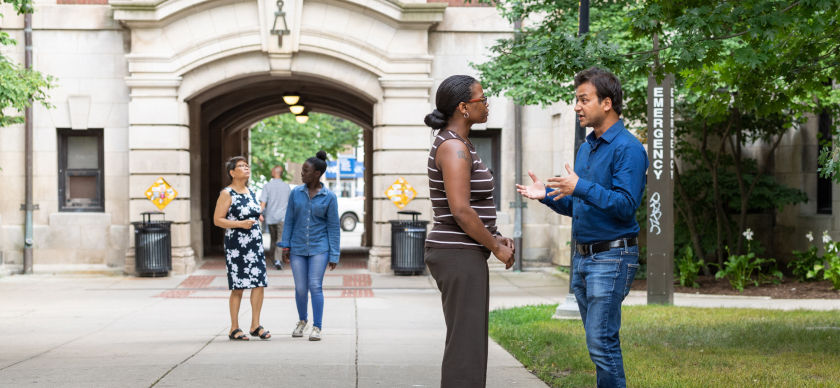 Two colleagues have a conversation in the diag