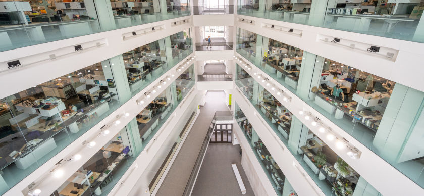 An interior view of a glass walled multi level building with many labs and offices